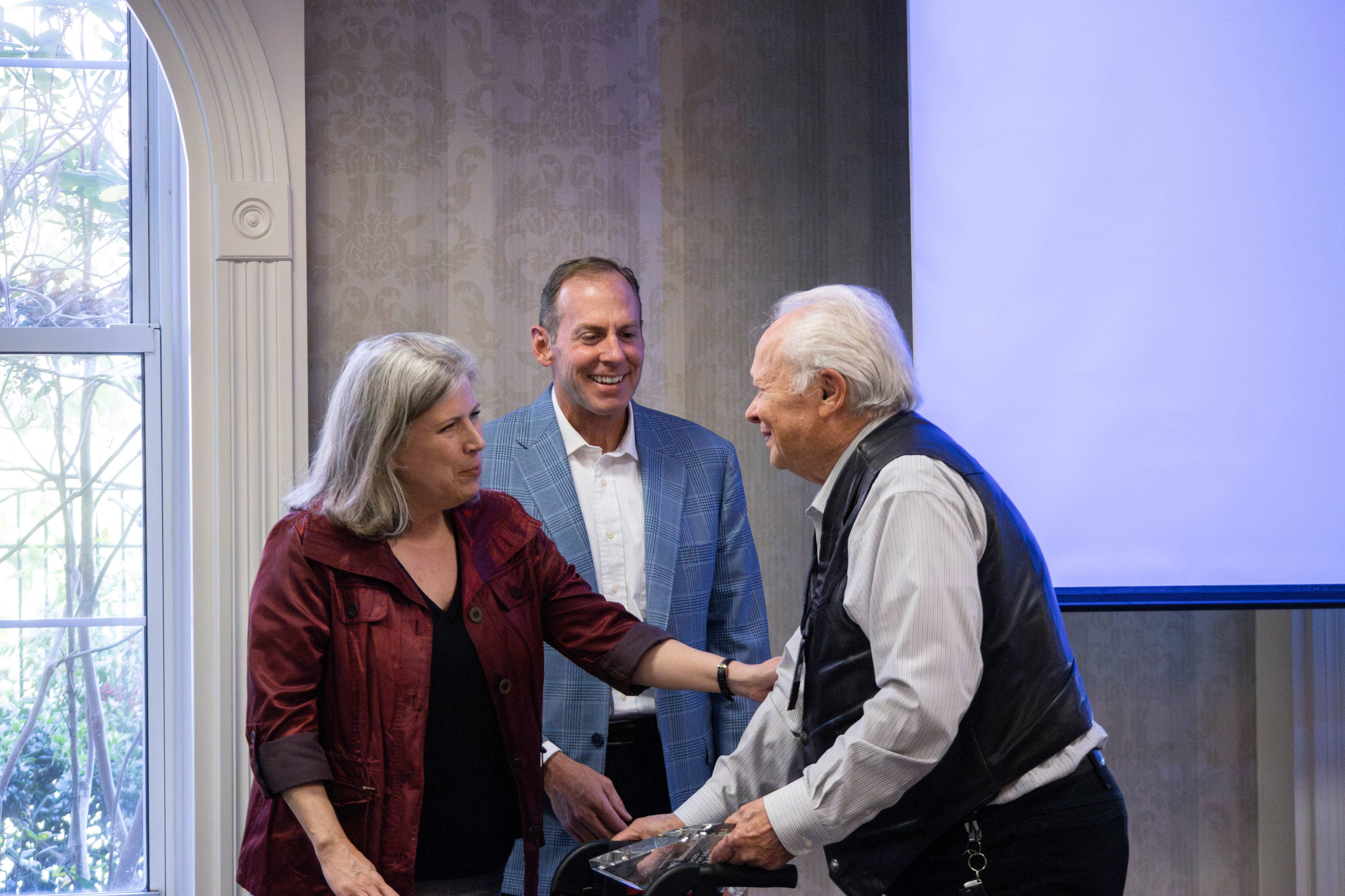 Three people smiling for an award