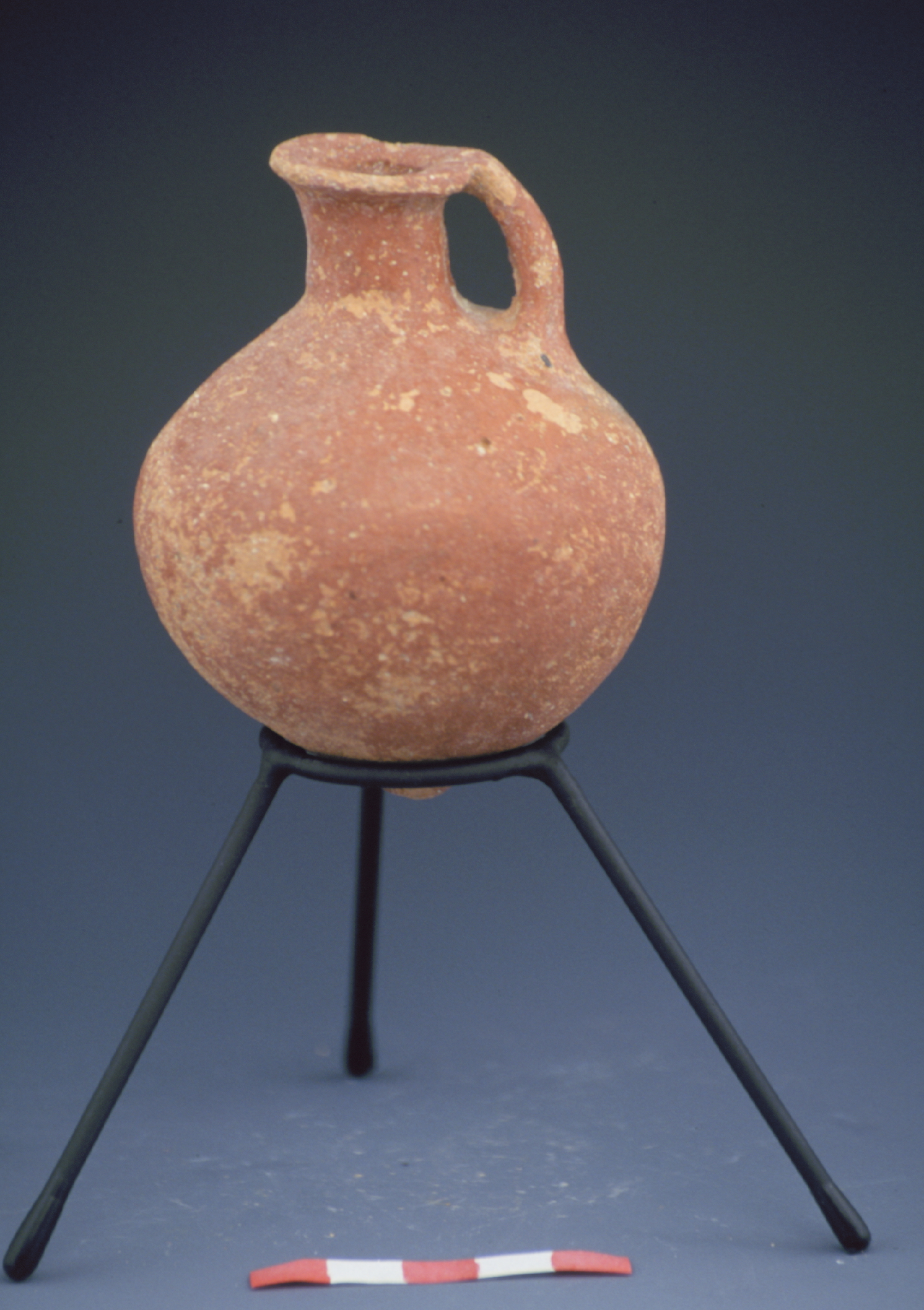 an orange juglet supported by a stand