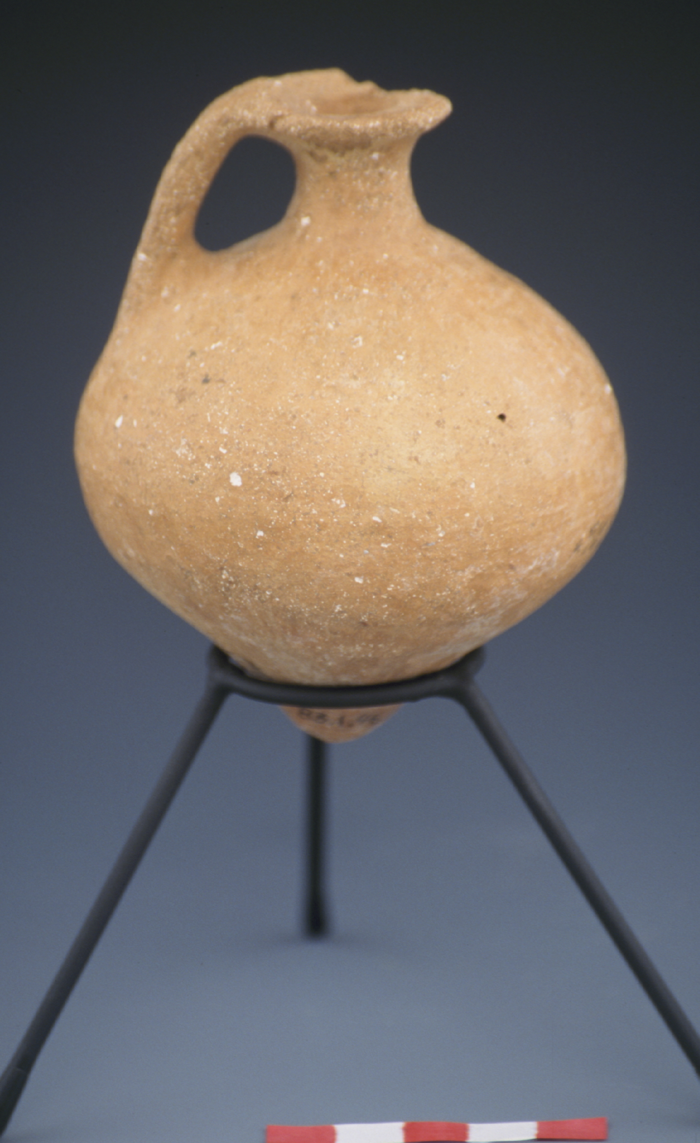 a light brown juglet supported by a stand