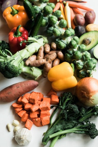Top view of a spread of fresh vegetables on a white table. 
